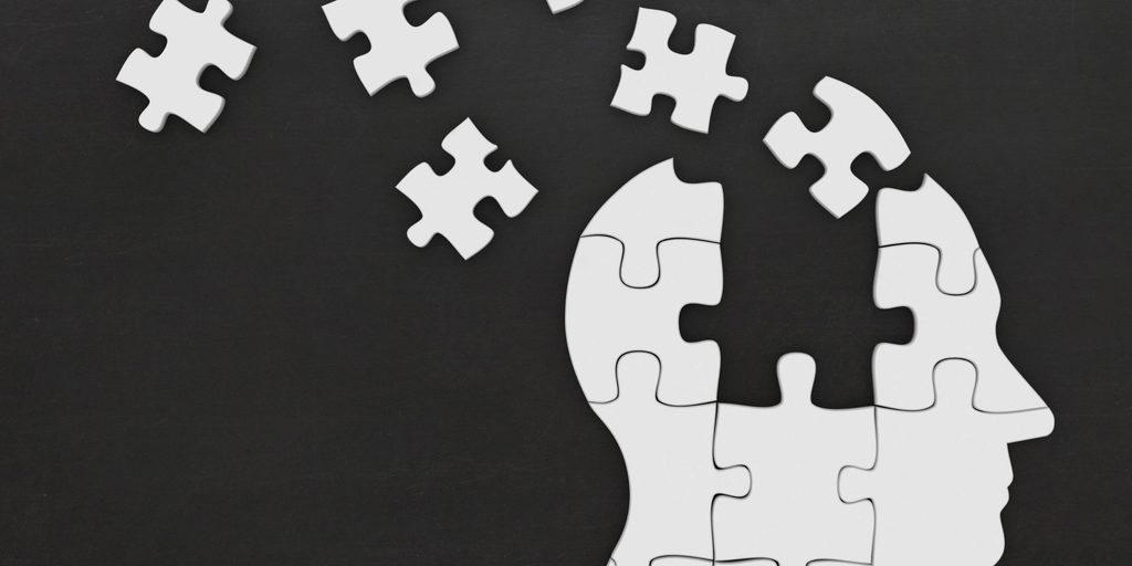 White puzzle pieces forming a human brain, symbolizing how to rebuild your brain, recover your memory, and improve brain health.